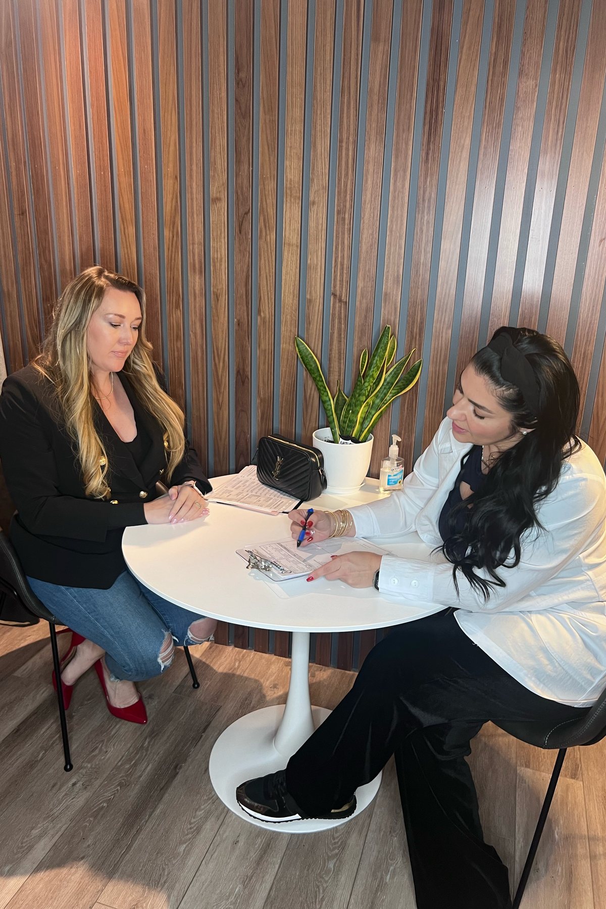 A clinician goes through goals and history with a client at the consult table