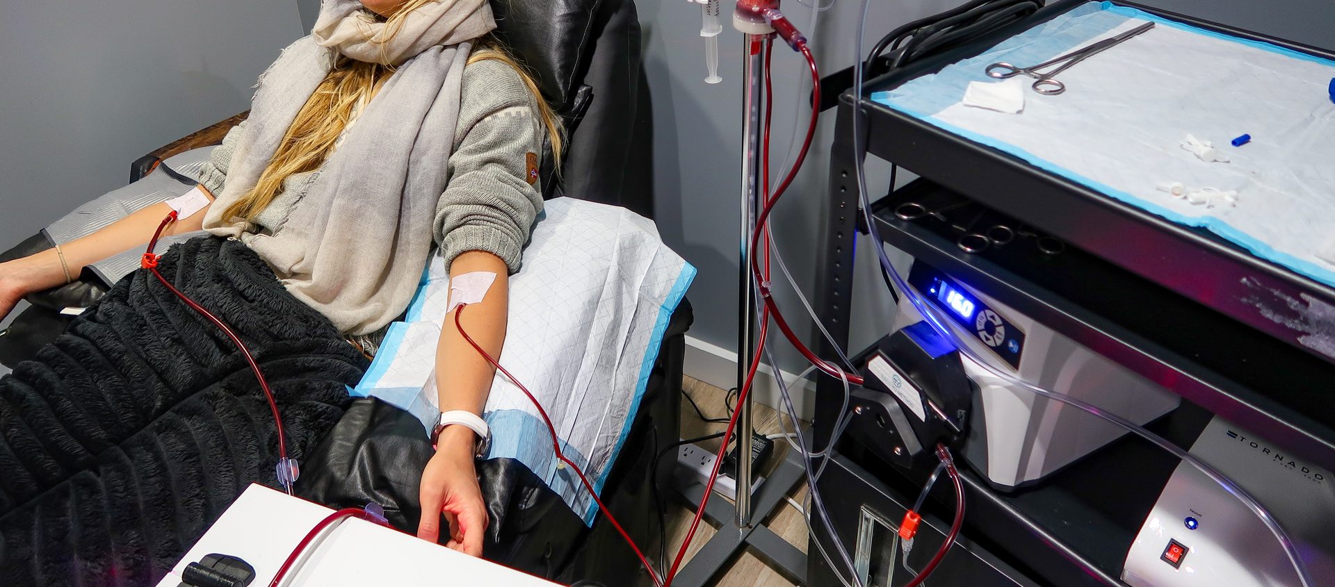 A client resting in the recliner while the EBOO loop runs beside the chair