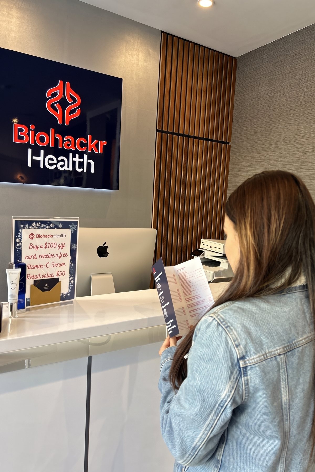 A client reviews her aftercare notes at the Biohackr Health front desk
